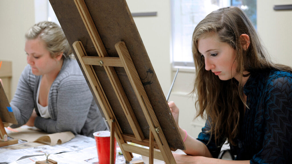 Students work on a painting during a class